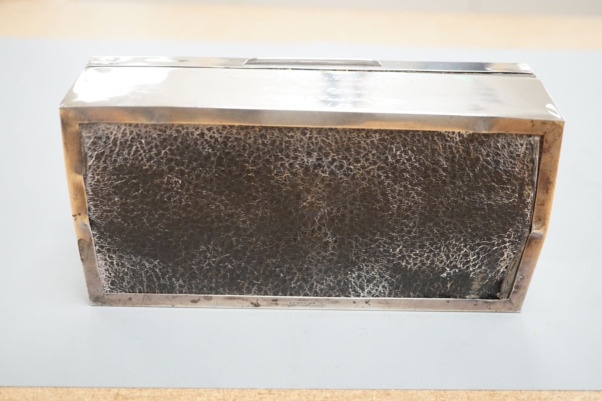 A late 1950's engine turned silver mounted rectangular cigarette box, with engraved inscription, 17.8cm.